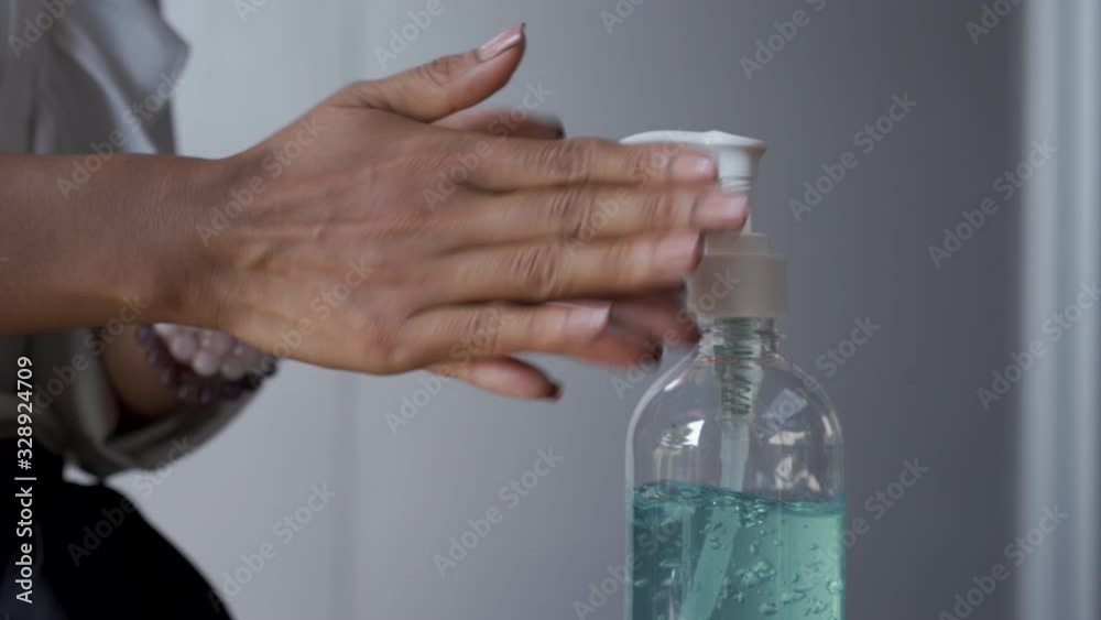 woman's hand is using an alcohol gel woman's hand is using an alcohol gel