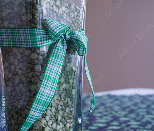 St Patricks Day vase arrangement with green ribbon over shamrock cloth