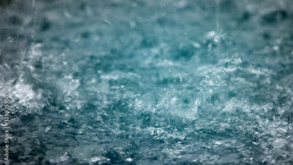 Raindrops make small bubbles in puddles, waves on the water surface