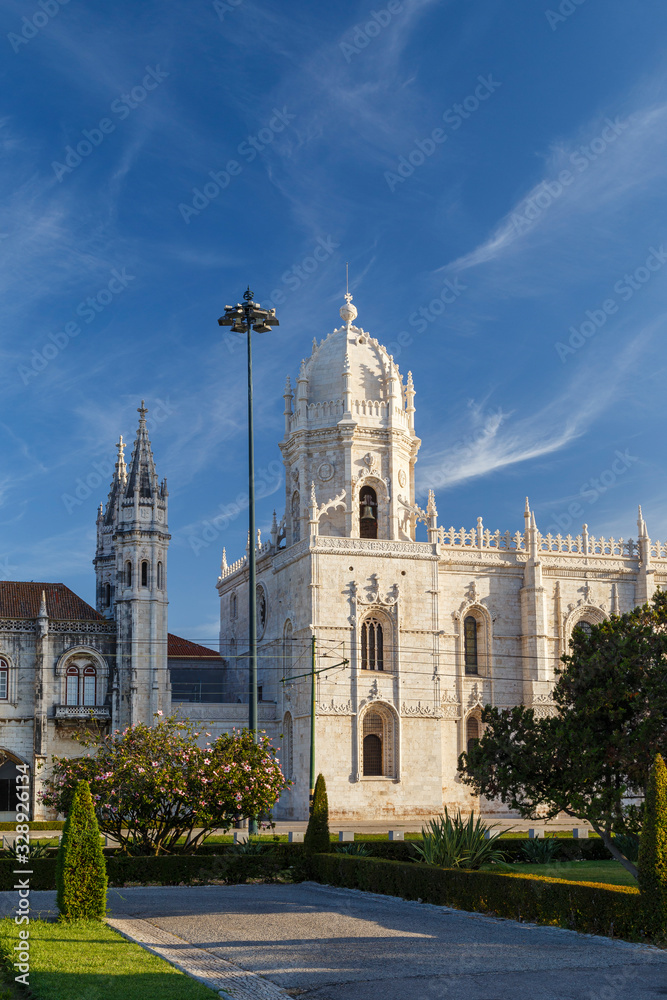 View of a park and the historic Mosteiro dos Jeronimos (Jeronimos Monastery) in Belem, Lisbon, Portugal, on a sunny morning.