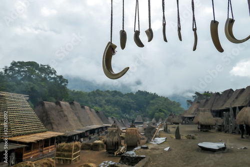Horns of different animals hanging below the rooftop of house in traditional Bena village in Bajawa, Flores Indonesia. Spiritualism, pictograms and totems. History and tradition mingling with presence photo