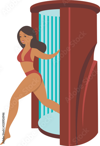Young tanned woman steps out of  solarium