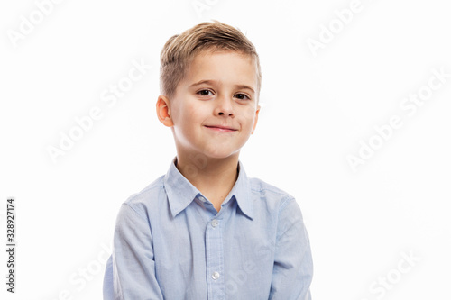 Laughing school-age boy with changing front teeth in a blue shirt. Isolated over white background