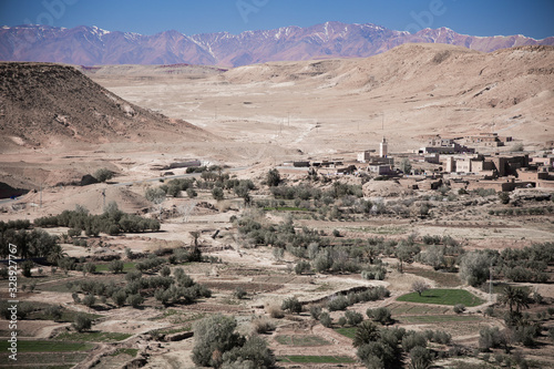 Oasis near the ancient village hidden under the hills and mountains on background