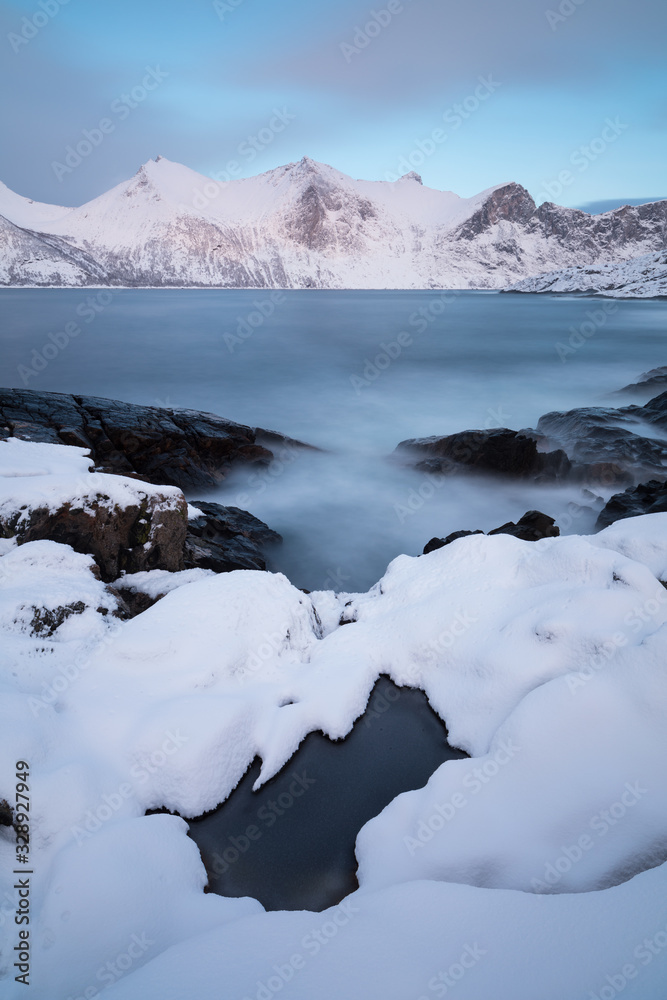 Panorama of snowy fjords and mountain range, Senja, Norway Amazing Norway nature seascape popular tourist attraction. Best famous travel locations. beautiful sunset within the amazing winter landscape