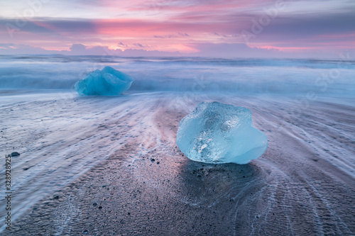 Beautiful sunset over famous Diamond beach, Iceland. This sand lava beach is full of many giant ice gems, placed near glacier lagoon Jokulsarlon Ice rock with black sand beach in southeast Iceland photo