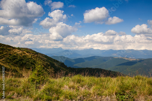 Beautiful mountain landscape, with mountain peaks covered with forest and a cloudy sky.