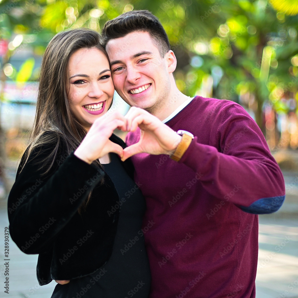 Young couple making a heart shape with their hands Young couple making a heart shape with their hands