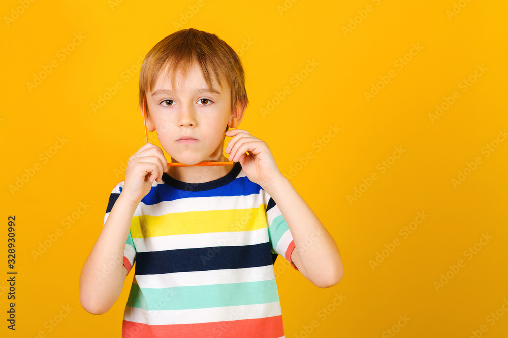 Face portrait of sad little boy. Sad tired frustrated boy over yellow background, copy space. Learning difficulties, education concept. Face portrait of sad little boy. Sad tired frustrated boy over yellow background, copy space. Learning difficulties, education concept.