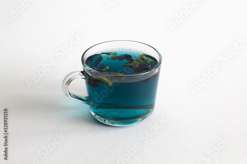 butterfly pea tea. glass cup of blue herbal tea on a white background. Healthy lifestyle. cup of hot blue tea with dry flowers on a white table. Fresh Cold drinks, blue cocktail. copy space.