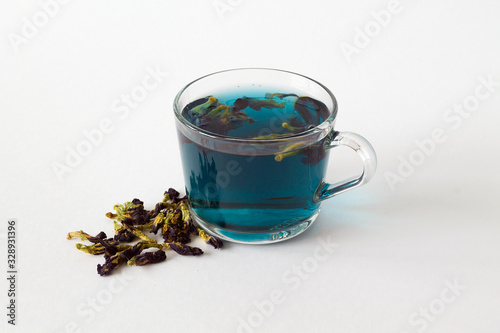 butterflu pea tea. glass cup of blue herbal tea on a white background. Healthy lifestyle. cup of hot blue tea with dry flowers on a white table. Fresh Cold drinks, blue cocktail. copy space. photo