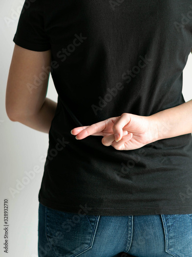 A woman hides a hand that posture forefinger and middle finger crossing together at her back when saying a lie.