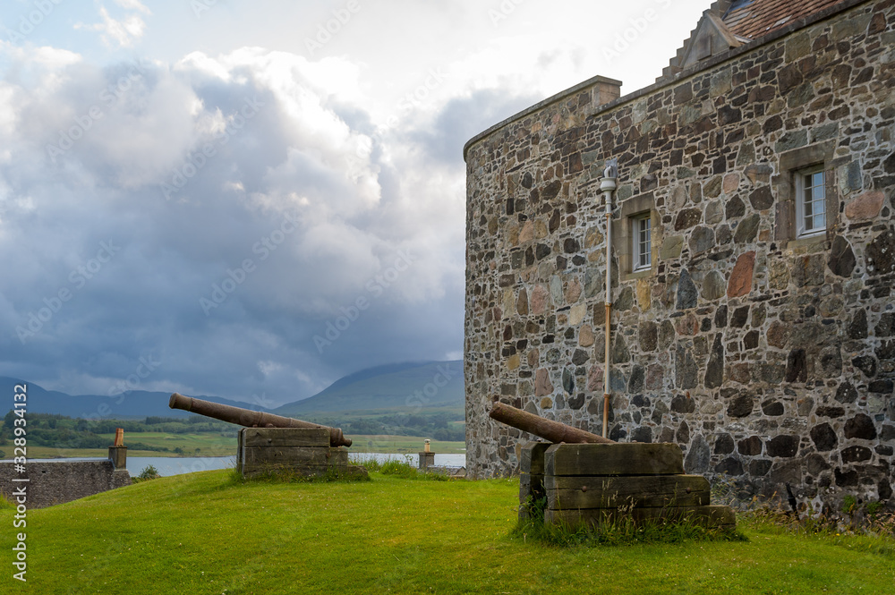 Medieval Duart Castle walls and old cannons with dramatic sky background. Island of Mull, Scotland.