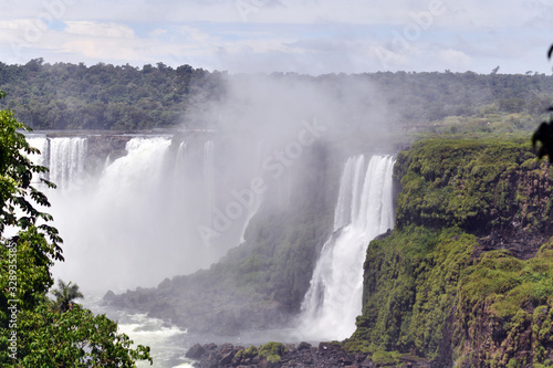 Iguazu roaring waterfalls against a jungle and gray sky