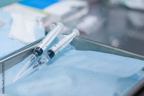 Two syringes with medicine lie in the treatment room, close up
