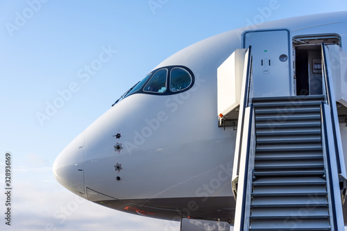 The cockpit and the entrance to the aircraft for passengers with a ladder and stairs up.