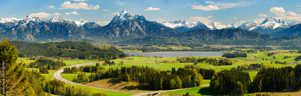 Plakat panoramiczny krajobraz z łąką i jeziorem przed alpami