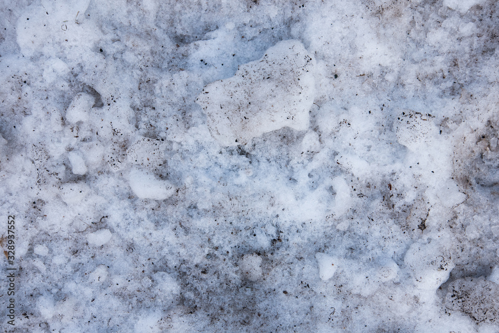 Chunks of dirty snow mixed with sand. Melting snow, spring. The transition from winter, the changing of the seasons. Background Chunks of dirty snow mixed with sand. Melting snow, spring. The transition from winter, the changing of the seasons. Background