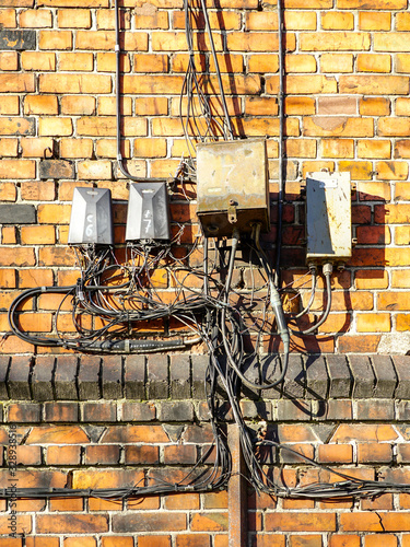 old wiring harness on a red brick wall photo