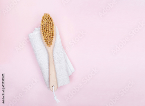  Brush for dry massage on linen towel over pink background. flat lay top view