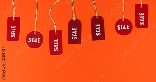 Stop motion paper price tags moving sale on a colored background.