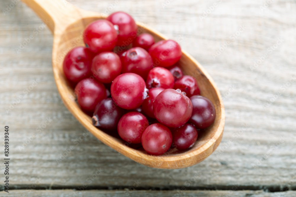 Fresh cranberries in a wooden spoon.
