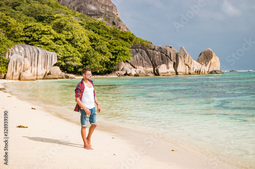 Seychelles tropical Island, Young man on the white beach during Holiday vacation Mahe Seychelles, Praslin Seychelles photo