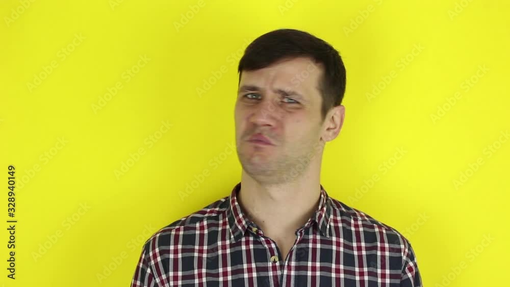 A funny handsome guy says no and shakes his head negatively. Portrait on a yellow background. A funny handsome guy says no and shakes his head negatively. Portrait on a yellow background.