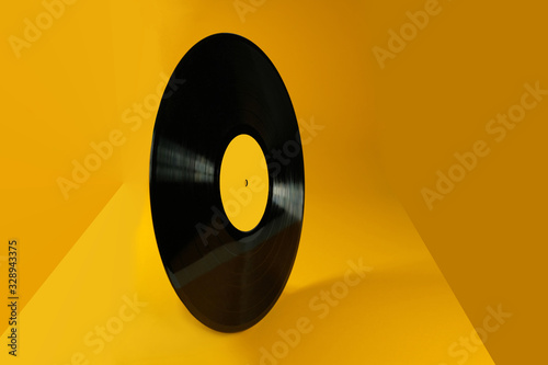 Vinyl record on an abstract yellow background. Old vintage vinyl record. photo