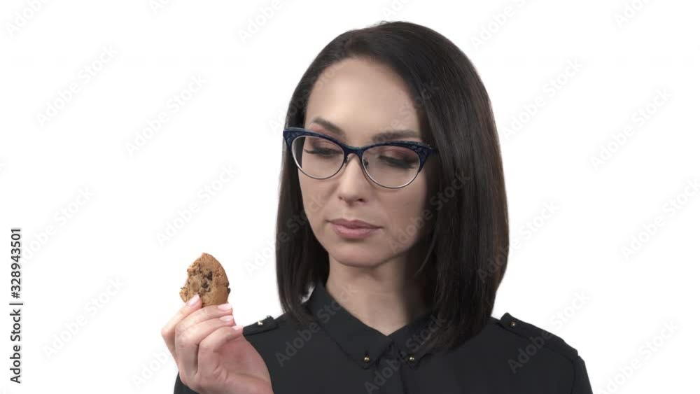 Portrait of a woman holding and tasting sweet cookie. Bakery and sweets. Isolated, over white background Portrait of a woman holding and tasting sweet cookie. Bakery and sweets. Isolated, over white background