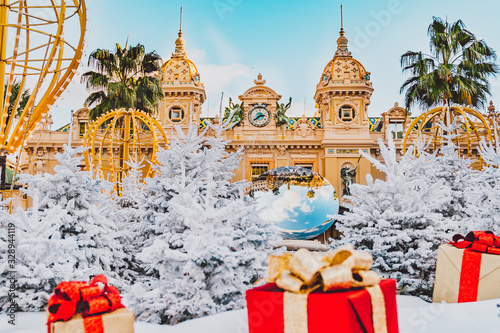 Monte Carlo Casino in Monaco, Cote de Azur, Europe. View of Grand Theatre, office of Les Ballets de Monte Carlo in winter. white Christmas tree, red gift boxes and New Year decorations.