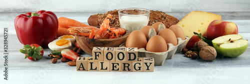 Allergy food concept. Allergy food as almonds, milk, cheese, strawberry, seeds, eggs, peanuts and .crustaceans or shrimps with wooden letter food allergy photo