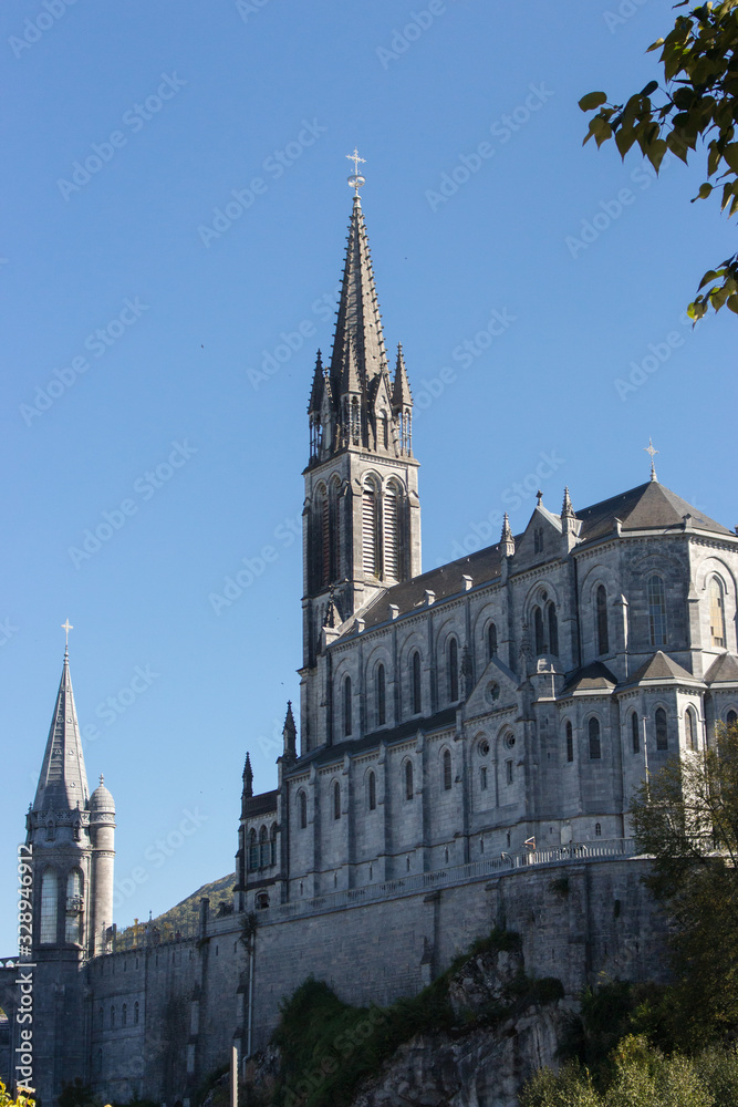 Lourdes, France - 10/01/2019: Sanctuary of Our Lady of Lourdes on sunny day. Spiritual centre of pilgrims. Medieval religious architecture. Basilica in Lourdes. Famous catholic cathedral. 