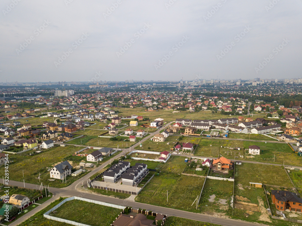 Aerial view of the village against the background of the far-sighted city on a summer day Aerial view of the village against the background of the far-sighted city on a summer day
