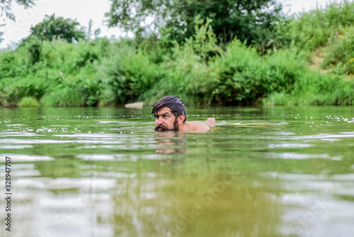 Real joy. summer vacation. mature swimmer. brutal hipster with wet beard. refreshing in river water. water beast. furry monster. wild man. time to relax. bearded man swimming in lake