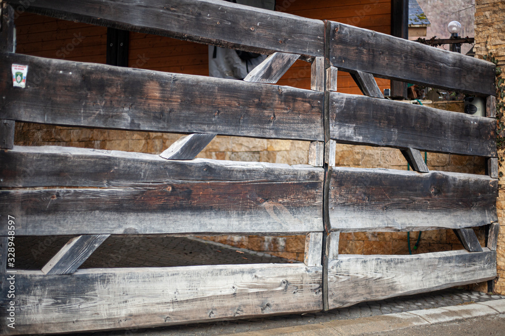 Wooden gate to the countryside. The fence on the farm. The construction of the boards. Check in for the car. Gate for cattle. Wooden gate to the countryside. The fence on the farm. The construction of the boards. Check in for the car. Gate for cattle.