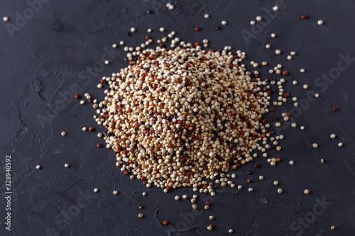 mix of quinoa grains on a dark stone background