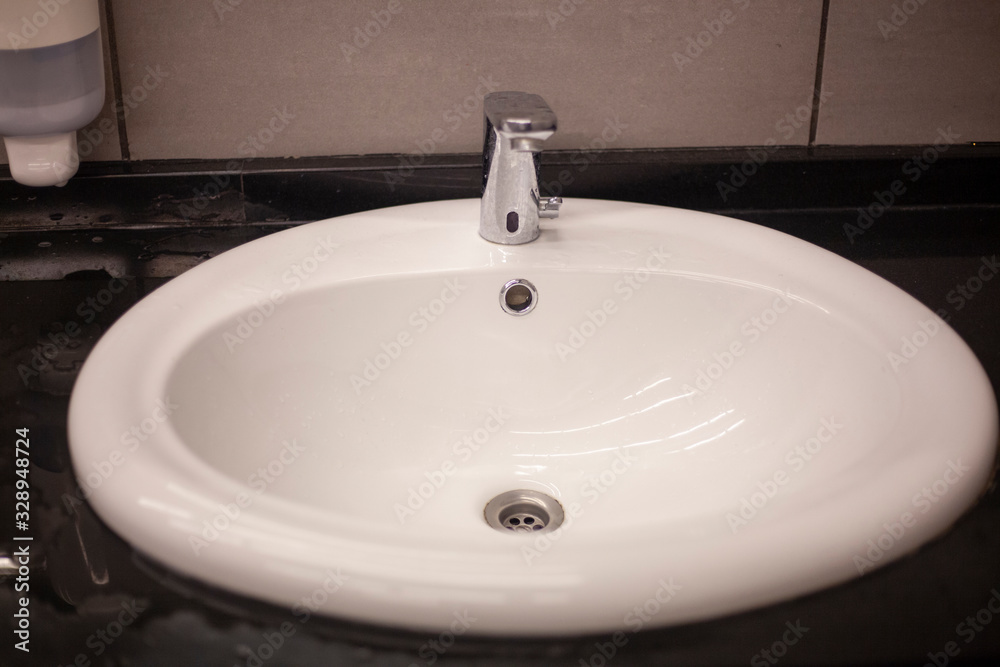 White sink in the mall. Dressing room. Place for washing hands. Cleaning in the bathroom. White sink in the mall. Dressing room. Place for washing hands. Cleaning in the bathroom.