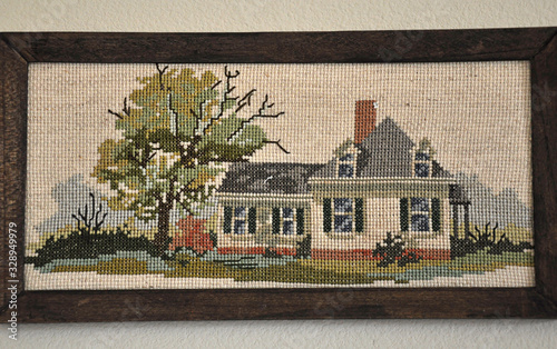 Cross stitched old house in frame