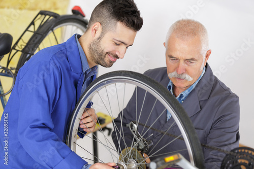 Mechanics working on bicycle wheel