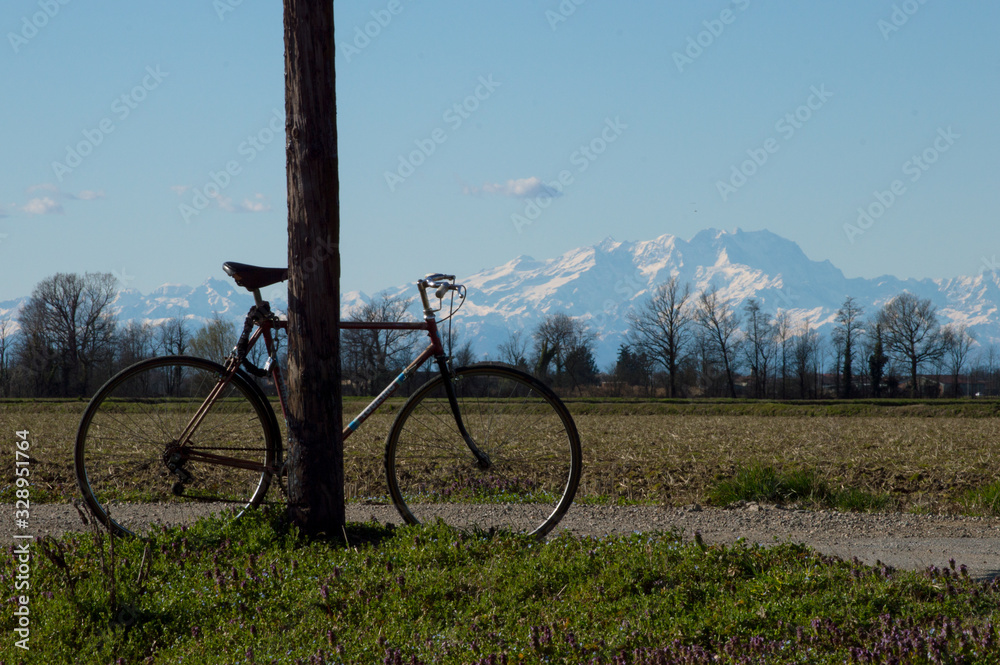 Farming landscape with the wonderful Alps mountains in the background in northern Italy just outside Milan. A bike tour on a sunny spring day