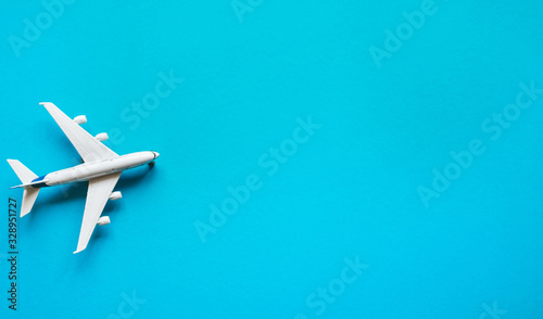 Plane on a pastel blue background with top view and copy space. Travel concept background Flat lay.
