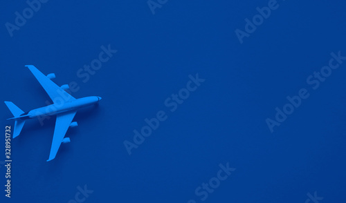 Toy plane on classic blue background with top view and copy space. Travel concept.