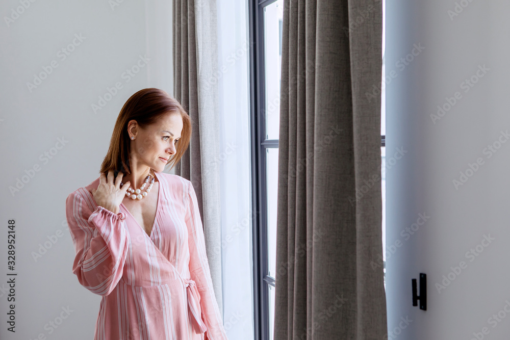 Beautiful woman in pajamas staring at the windows Beautiful woman in pajamas staring at the windows