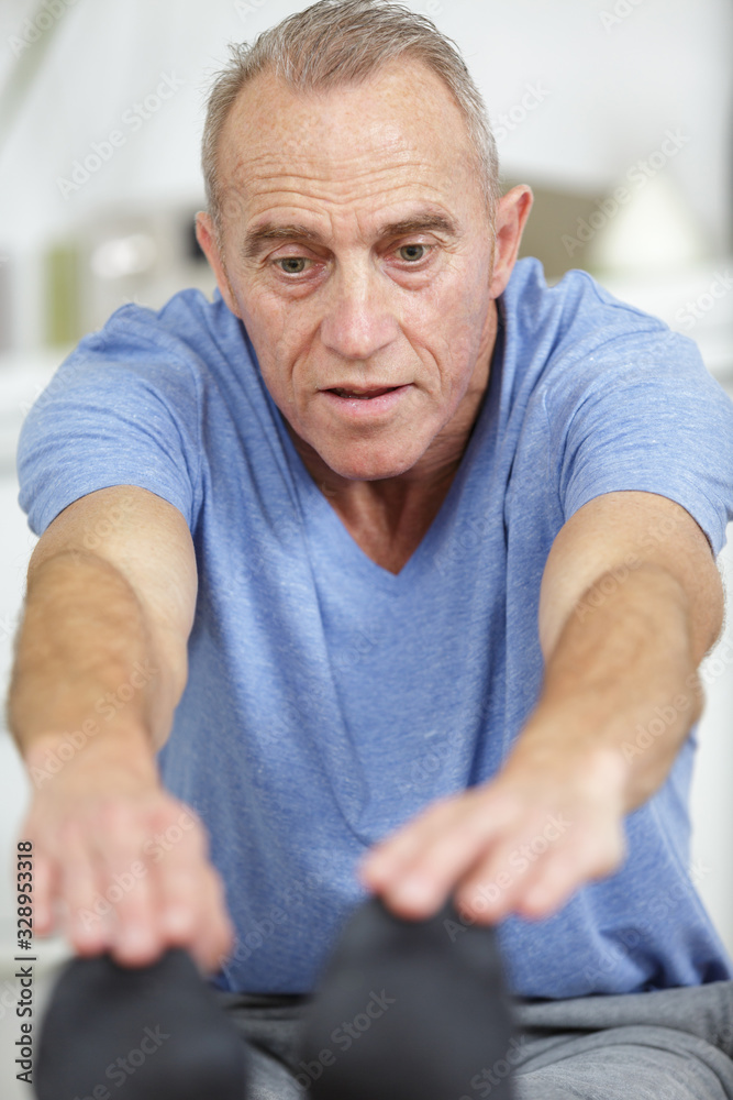 Fototapeta premium senior man doing recovery excersises at home