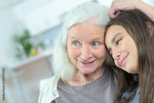 happy grandmother embracing granddaughter at home