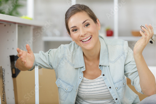 a happy woman assembling furniture