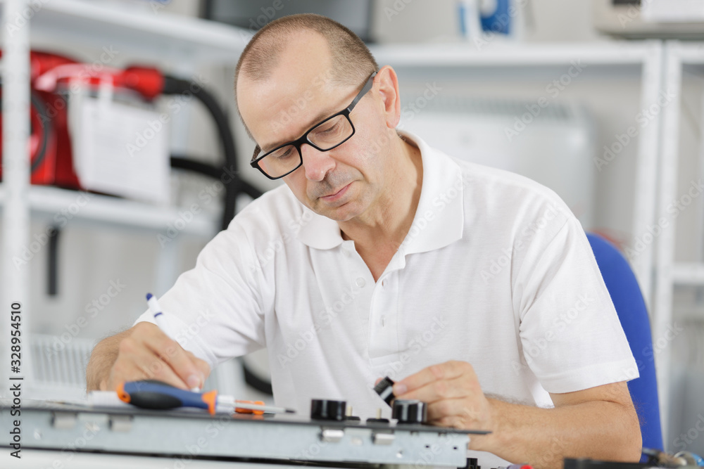 technician fixing motherboard by soldering chips
