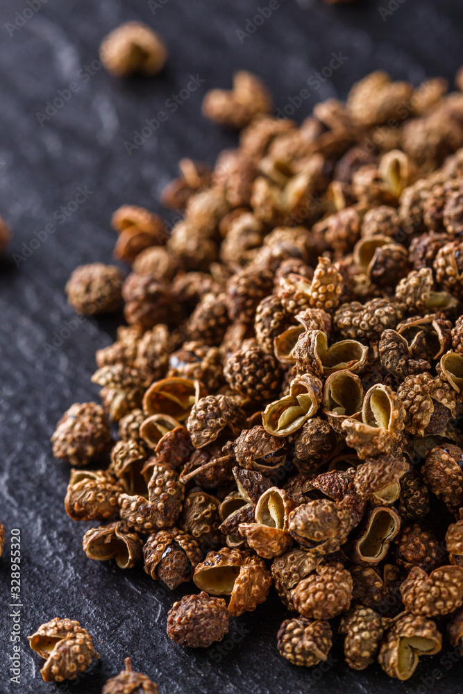 Obraz premium Sichuan pepper on a dark stone background
