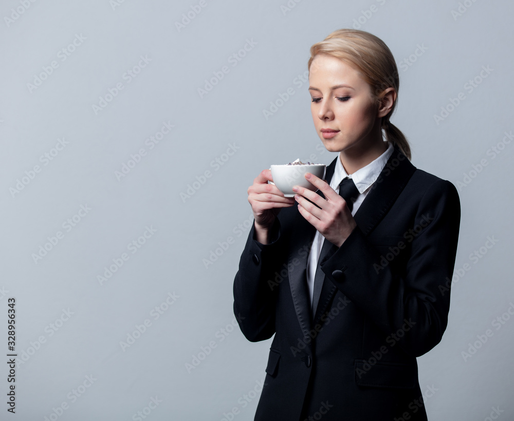 businesswoman in a classic black business suit with cup of coffee businesswoman in a classic black business suit with cup of coffee